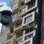 security CCTV camera or surveillance system with construction site on blurry background